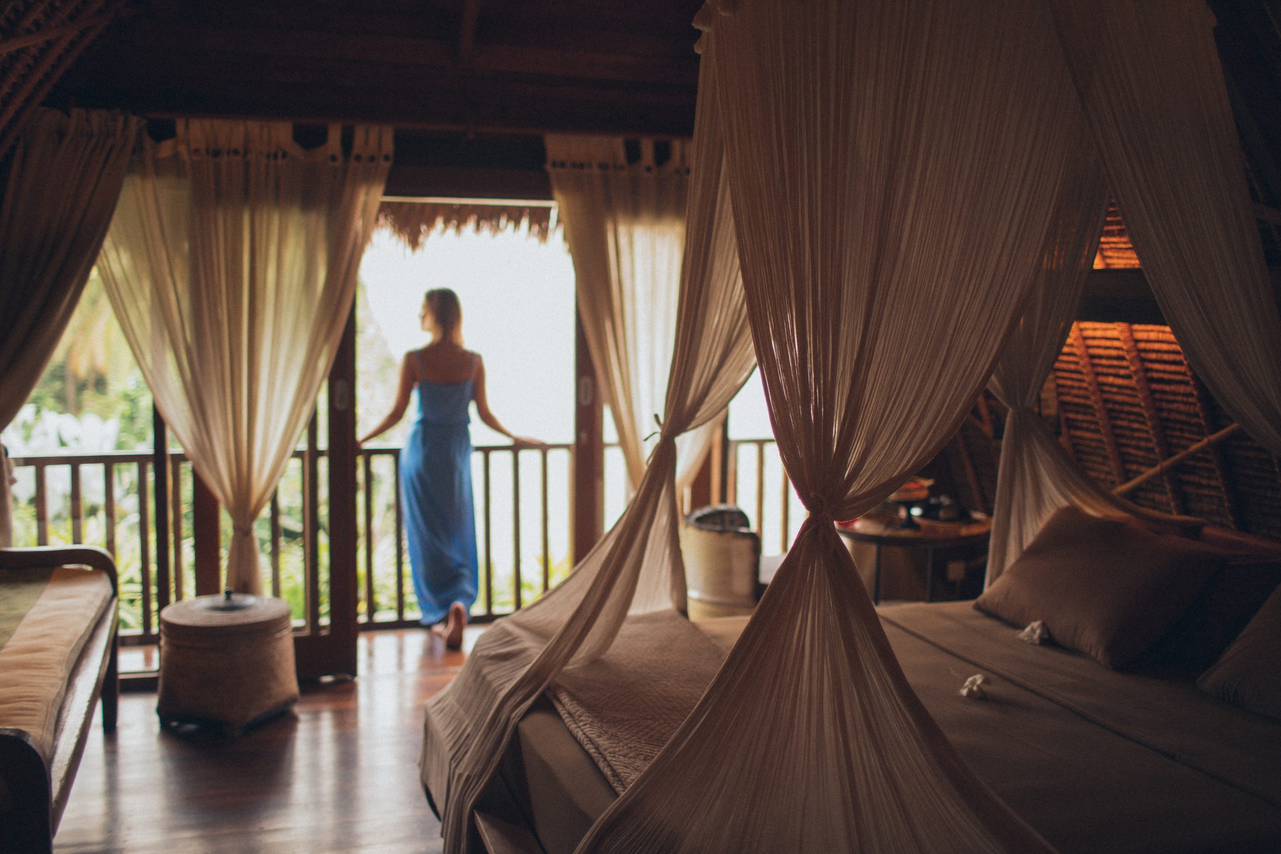 A female influencer standing on the balcony of her hotel room.