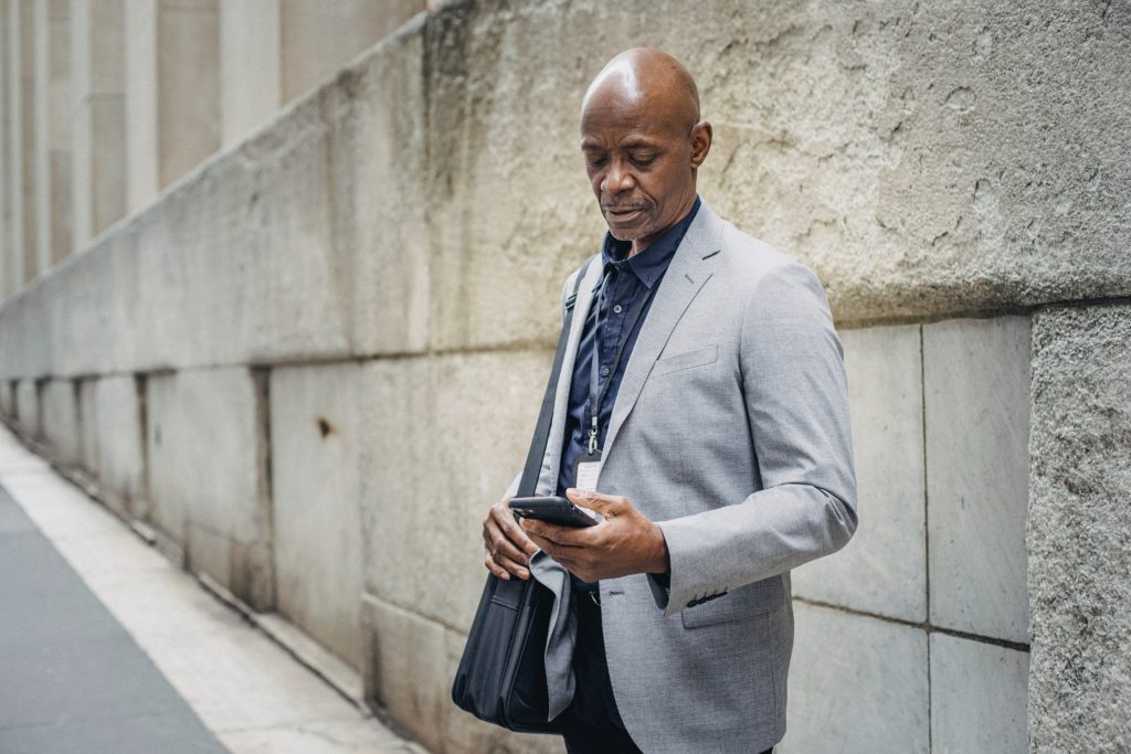 An executive dressed in business attire looking at their phone. 