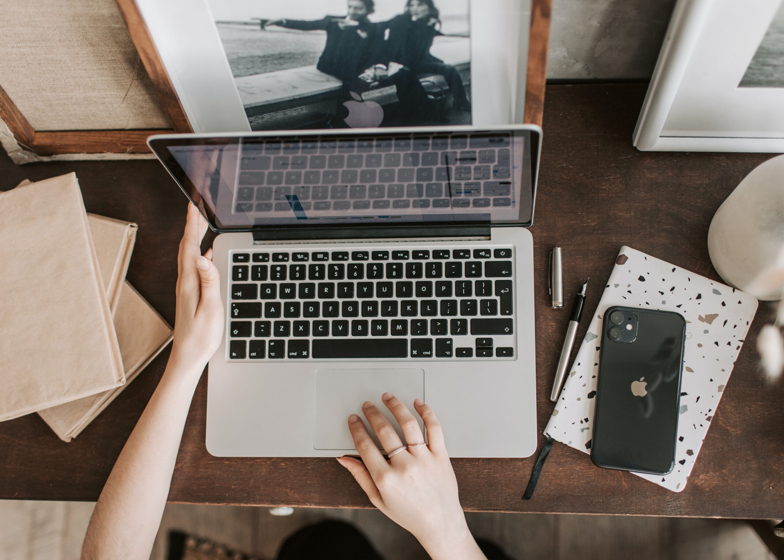 A social media manager using their favorite social media management tools on their computer sitting at their desk. The photo is an aerial view of them at their desk.
