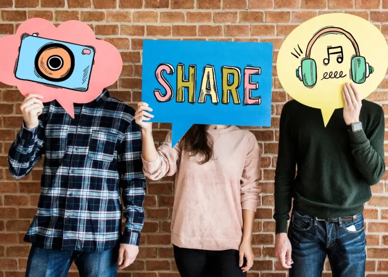 three people in front of a brick wall holding social media themed talk bubbles in front of their faces