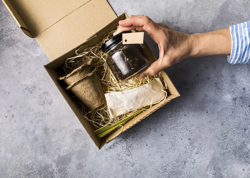 close up of a gift box with a hand removing a jar of jam