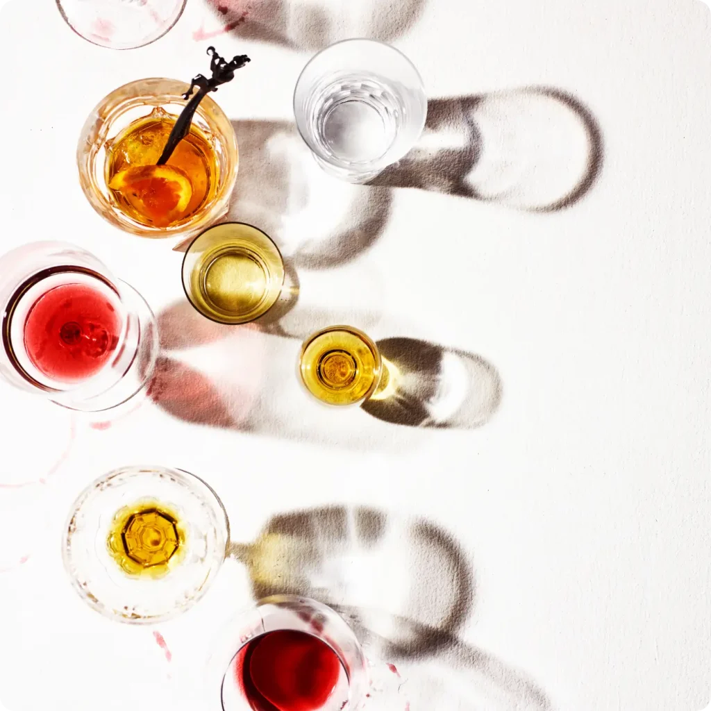 top down view of various glasses on a tabletop with various colored beverages in them