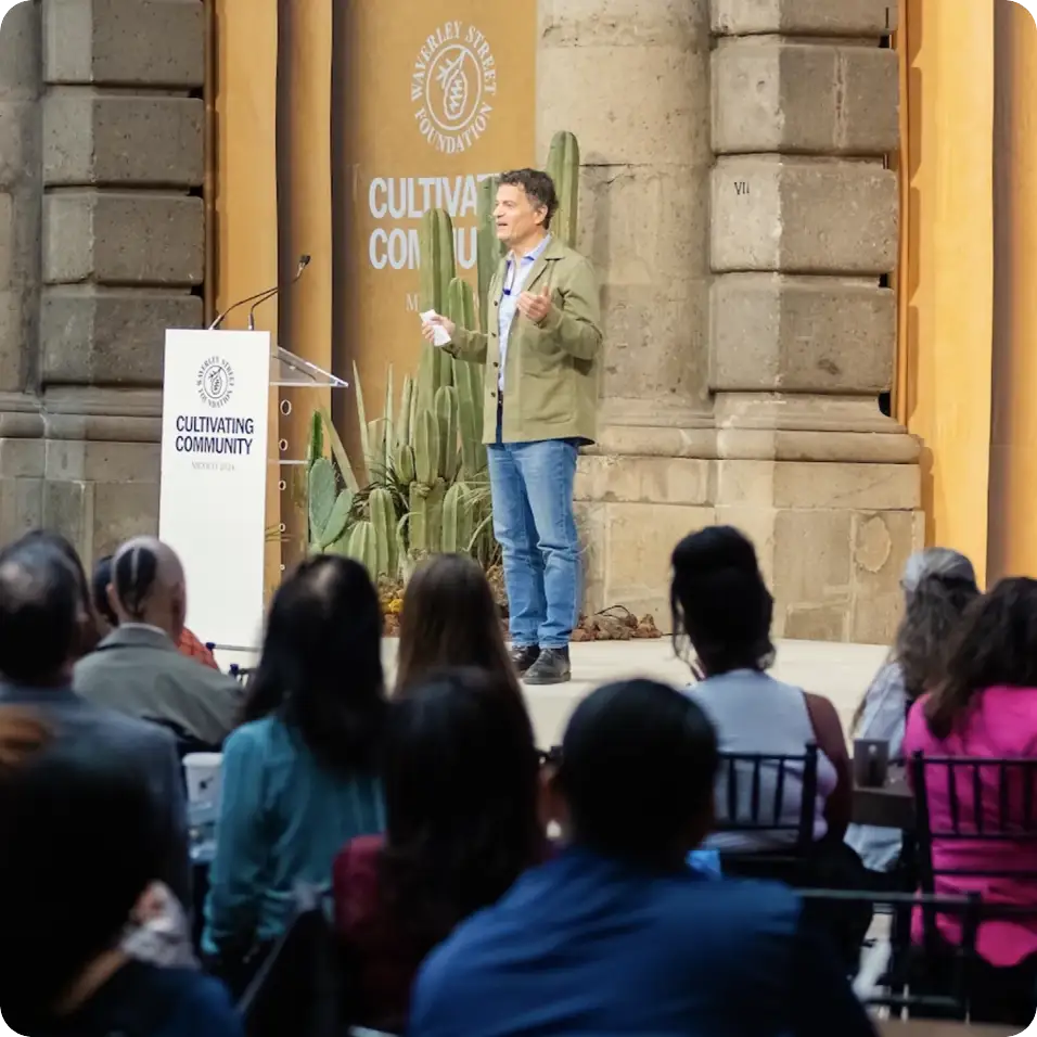 a man speaking to a cround from a stage