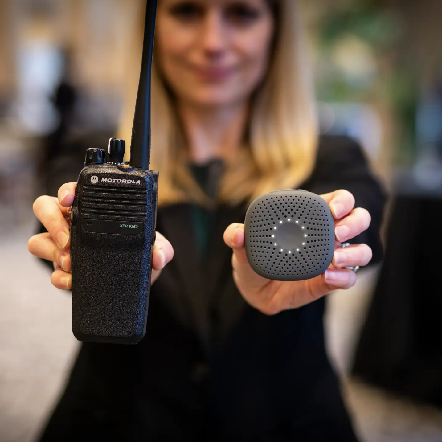 woman holding out a motorola handset and little speaker