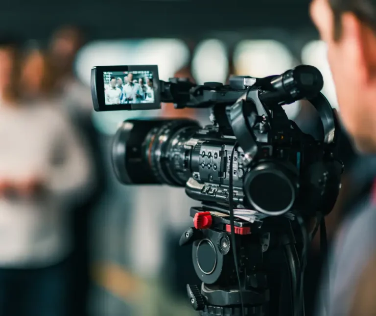 close up of a video camera filming a group of people